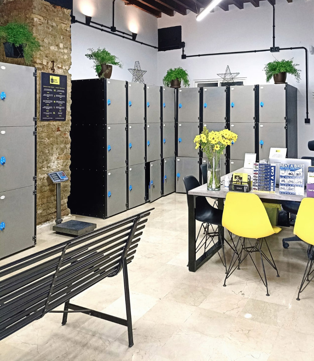 Lock & Relax interior: luggage storage lockers and reception with desk and chairs, providing comfort and security for visitors.