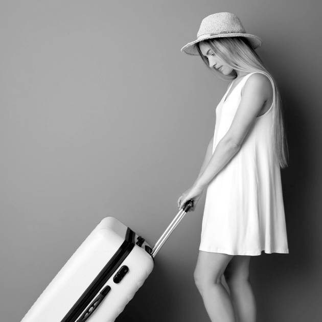 Young girl carrying a medium suitcase with wheels, exemplifying the luggage storage options for medium suitcases at Lock & Relax in Malaga.